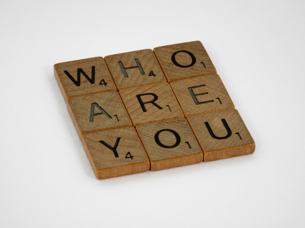 Scrabble tiles that spell,m Who Are you?